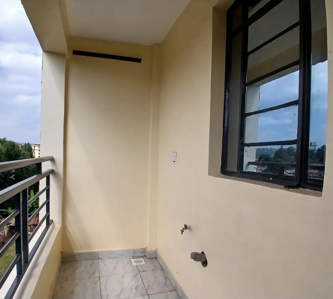 Compact balcony with black-framed window and city views