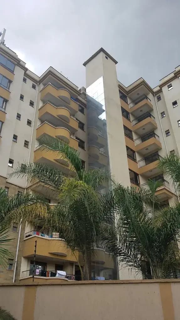 Multi-story residential building with balconies and palm trees