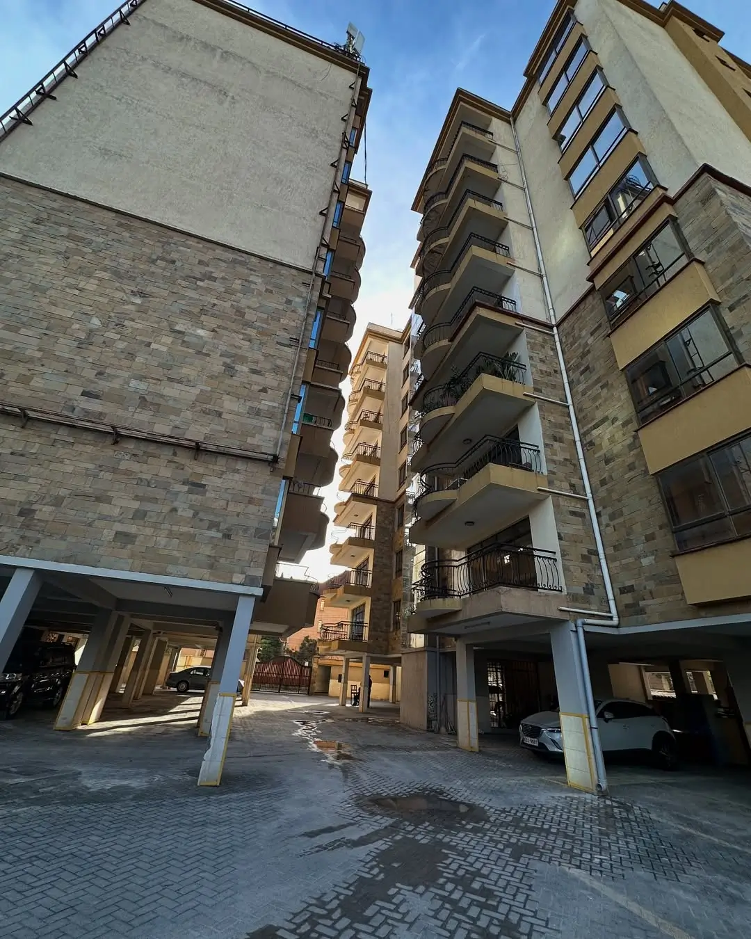 Modern residential building complex with ground-level parking and shops