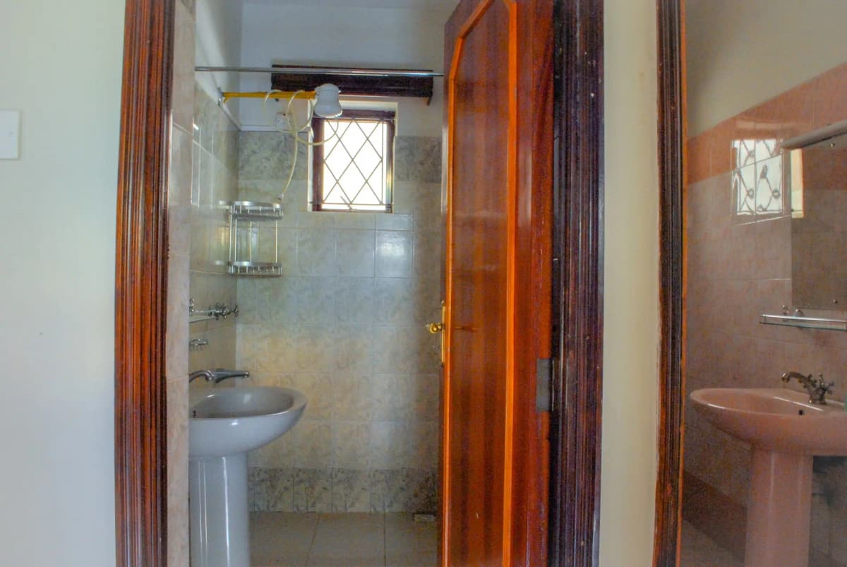 Compact bathroom with pedestal sink and shower enclosure