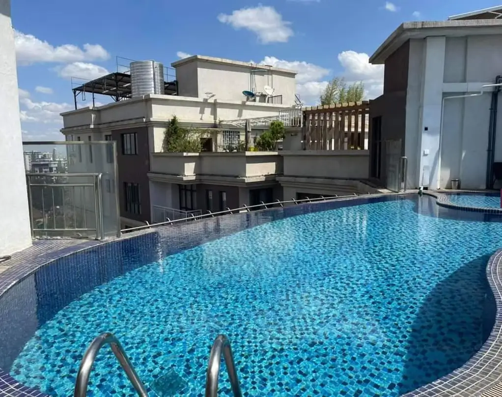 Rooftop swimming pool with city skyline views and modern building