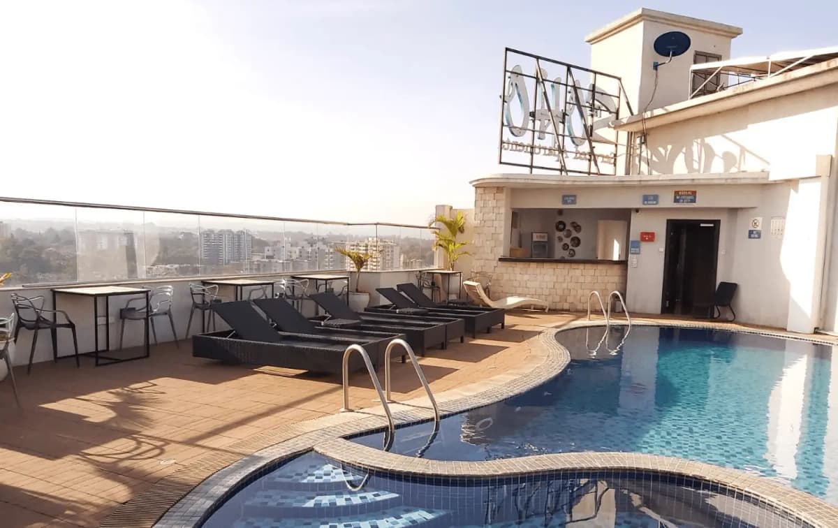 Rooftop pool deck with loungers, city views, and amenities