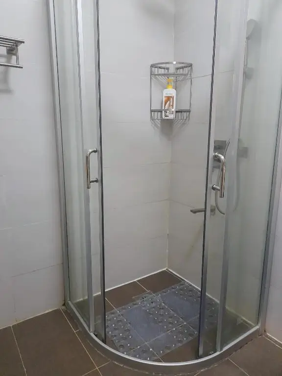 Modern enclosed shower stall with glass doors and chrome fixtures