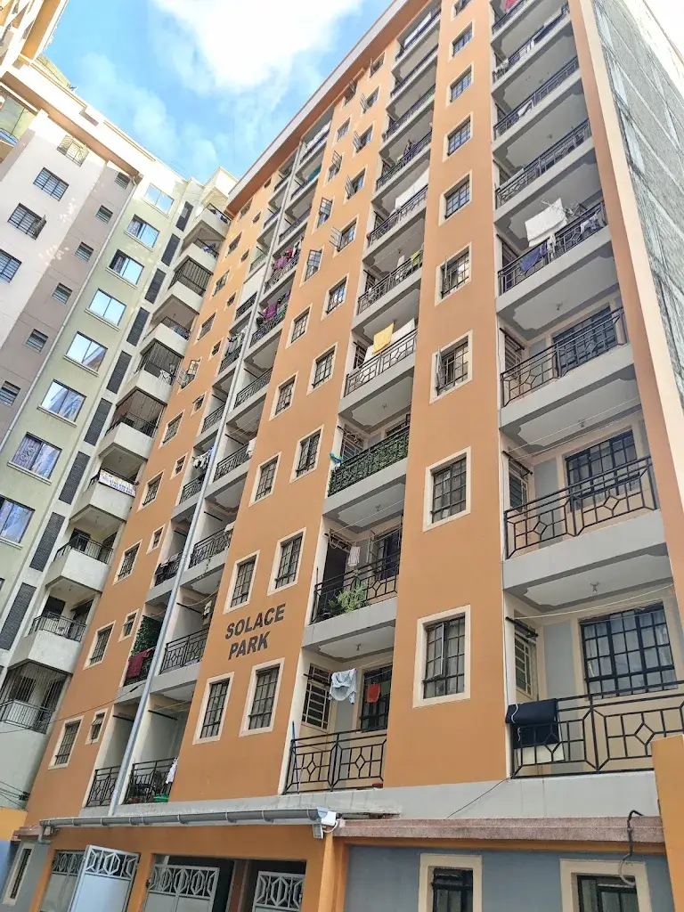Multi-story residential building facade with orange and gray exterior