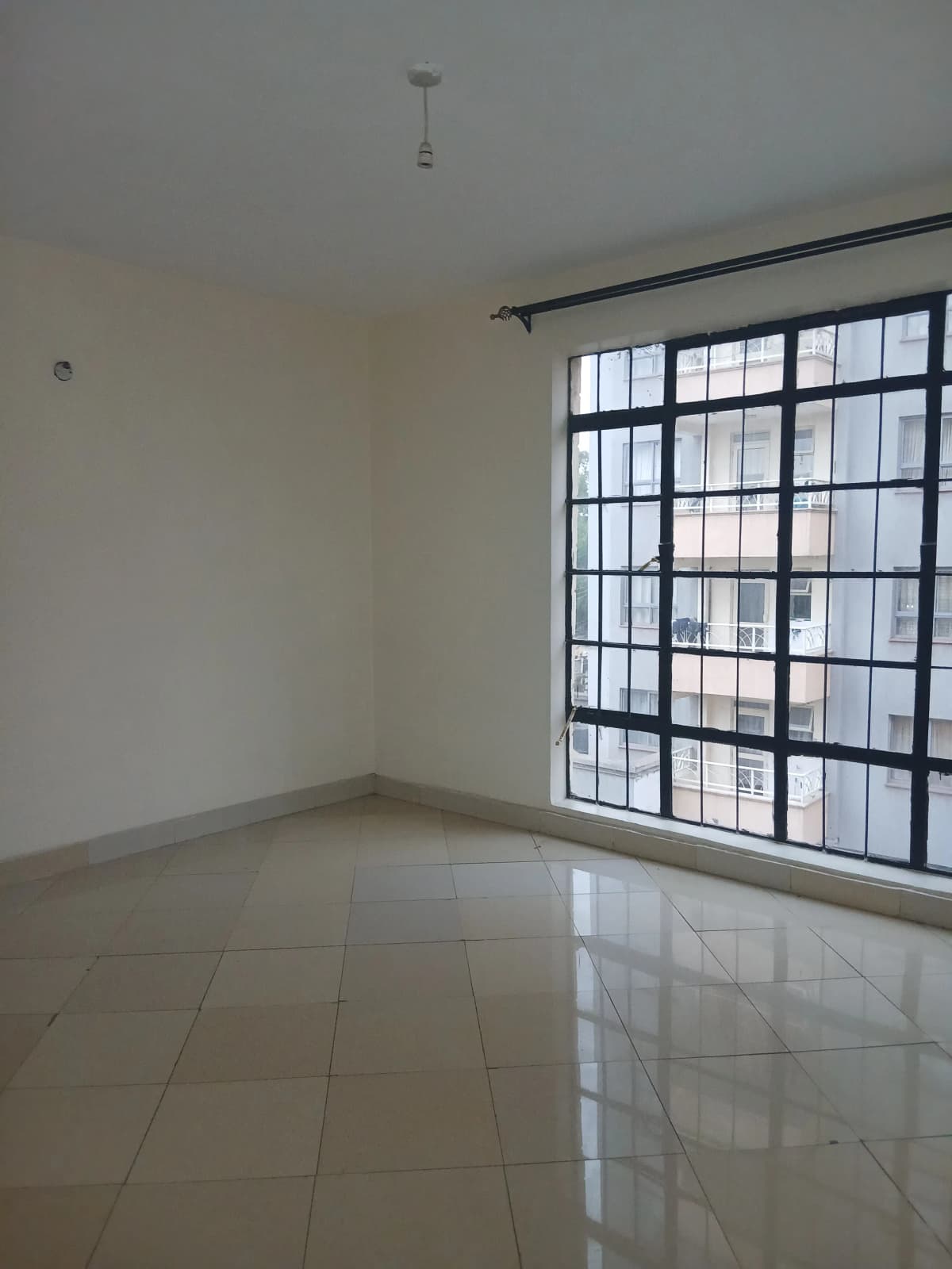 Spacious empty living room with large barred windows