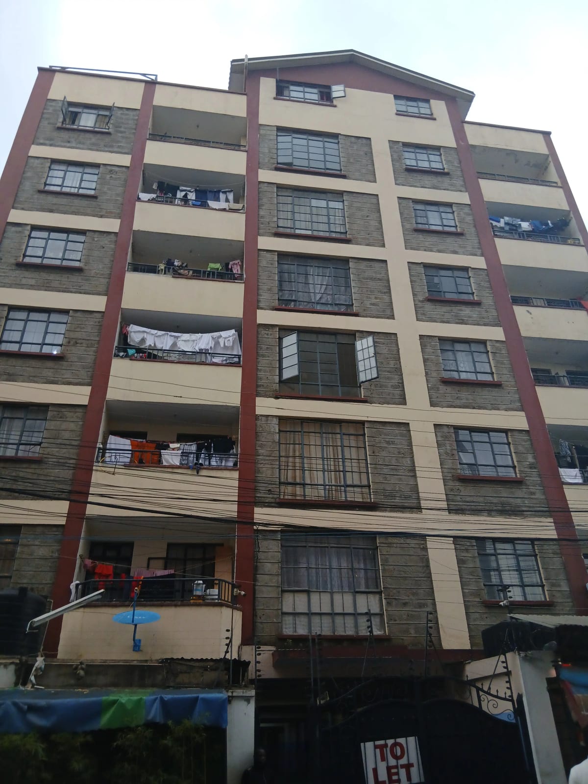 Multi-story residential building facade with balconies and mixed cladding