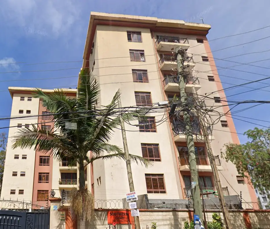 Multi-story residential building facade with balconies and palm trees