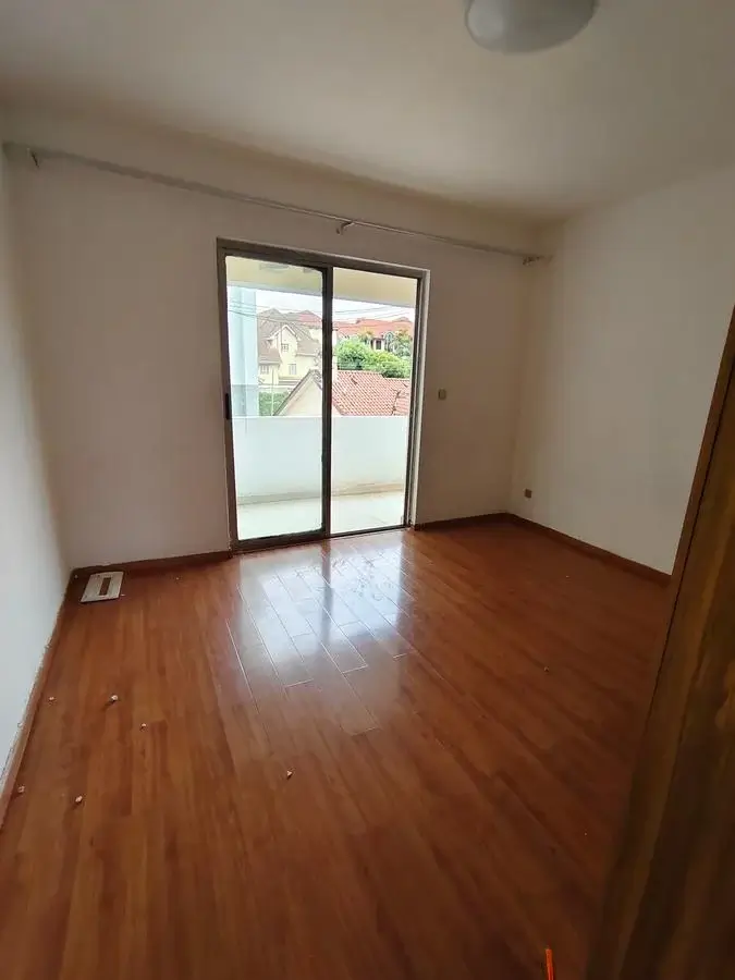Spacious living room with wooden floors and balcony access