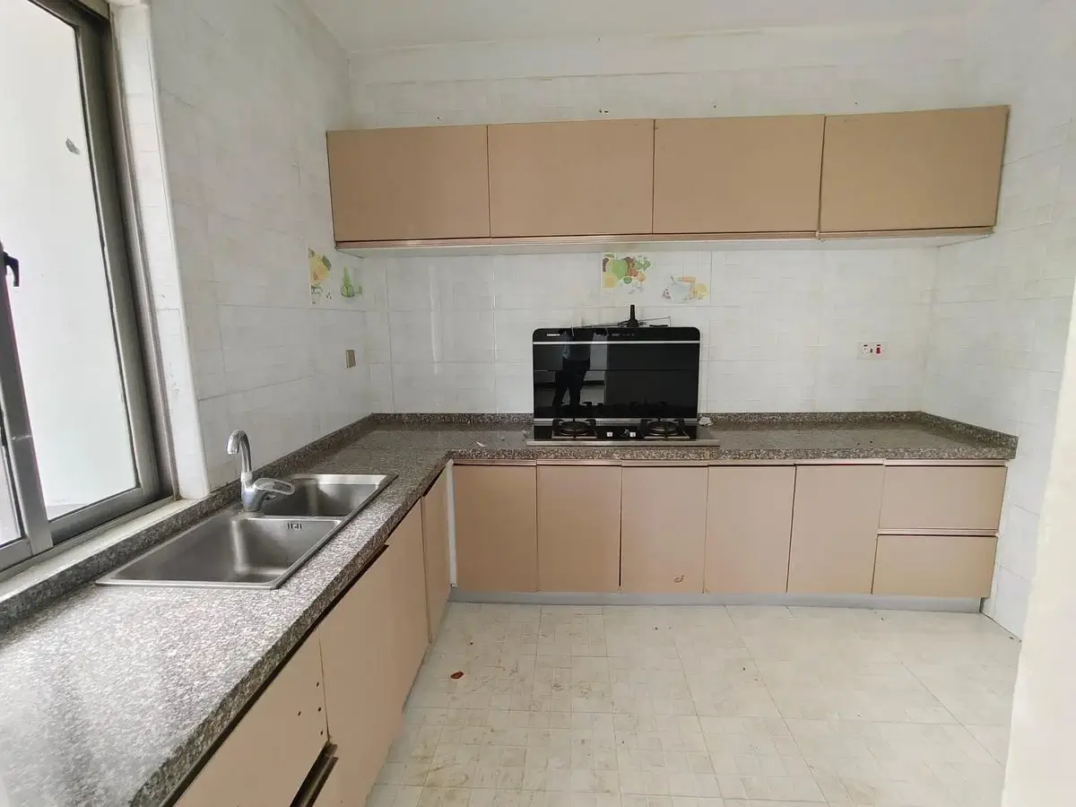 Modern kitchen with beige cabinetry, granite countertop, stainless steel sink
