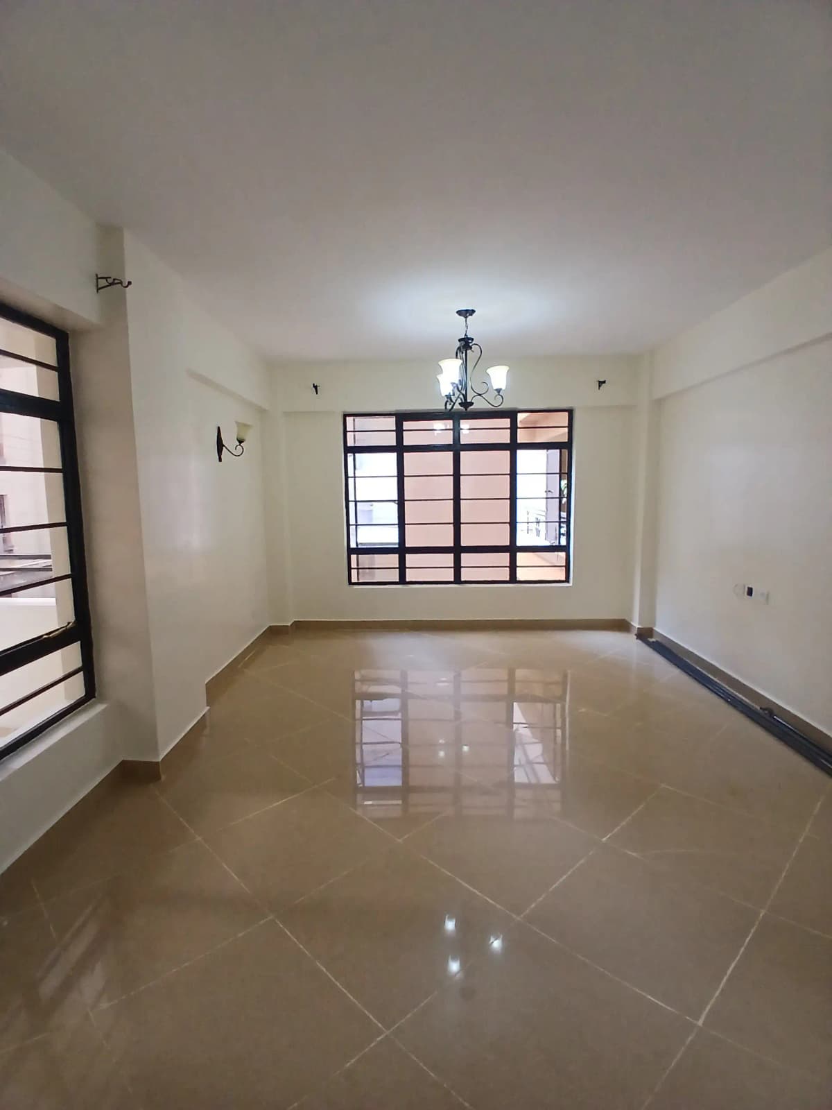 Empty living room with polished floor and large windows