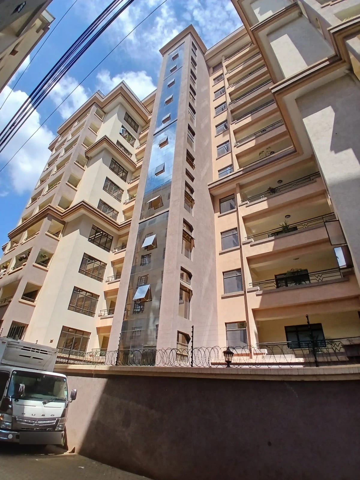 Multi-story residential building facade with balconies and parking