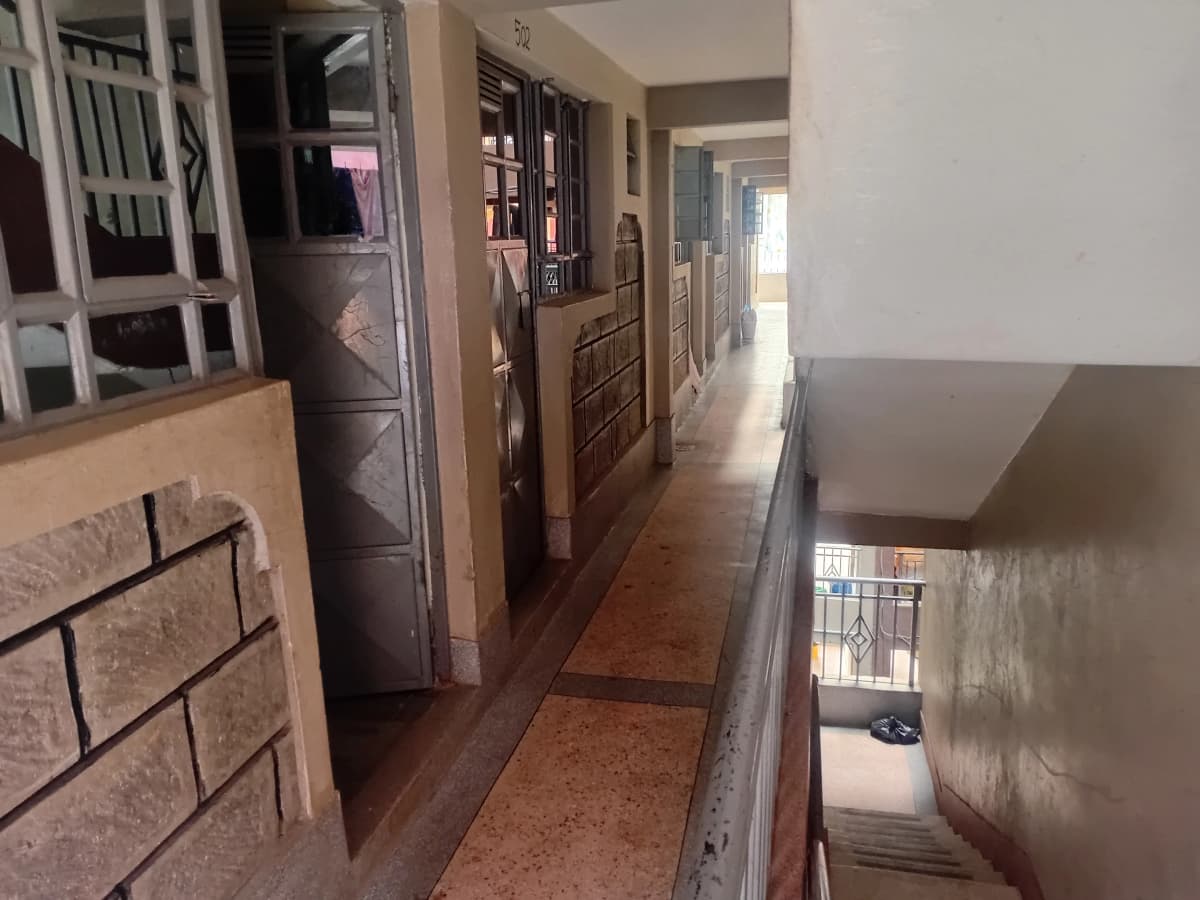 Long hallway with wooden doors and cork flooring