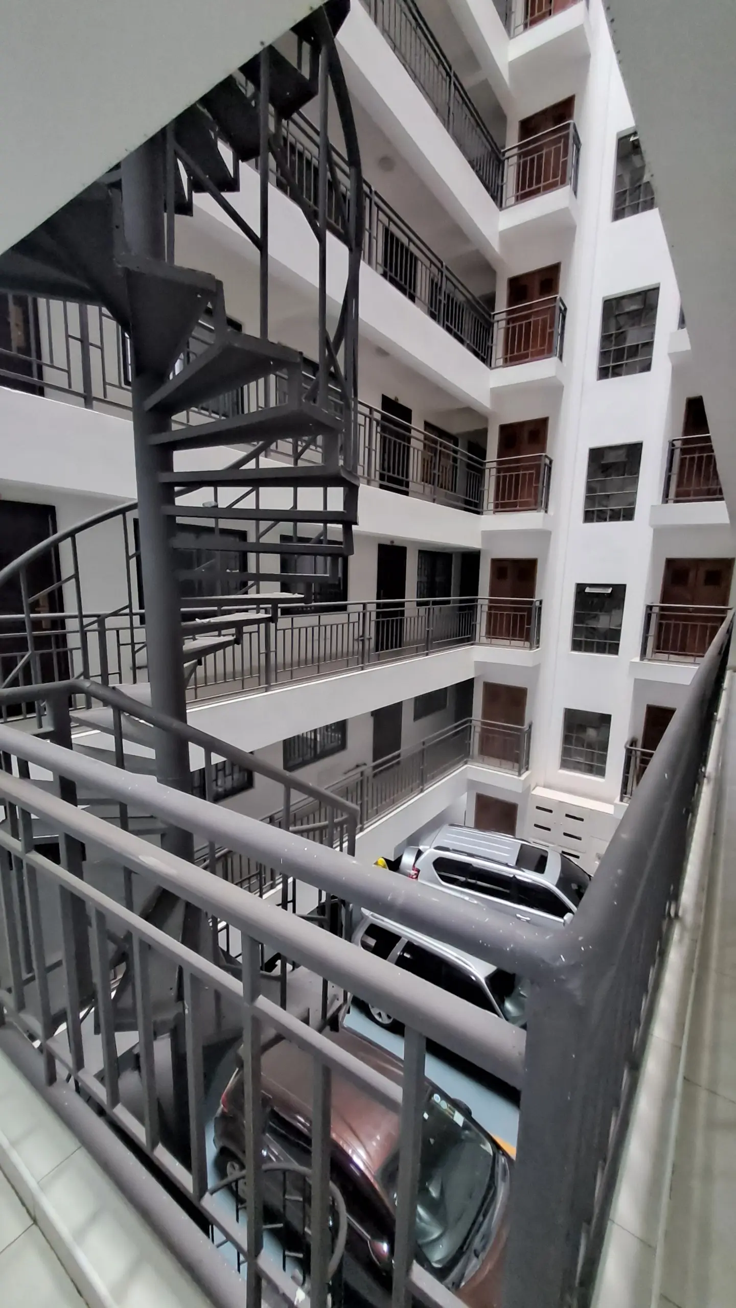 Multi-story residential building facade with spiral staircase