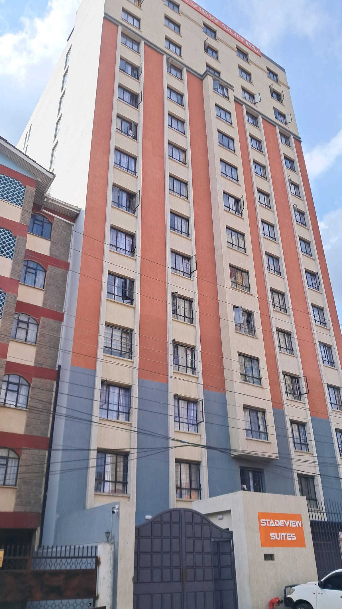 Multi-story residential building with red and cream facade
