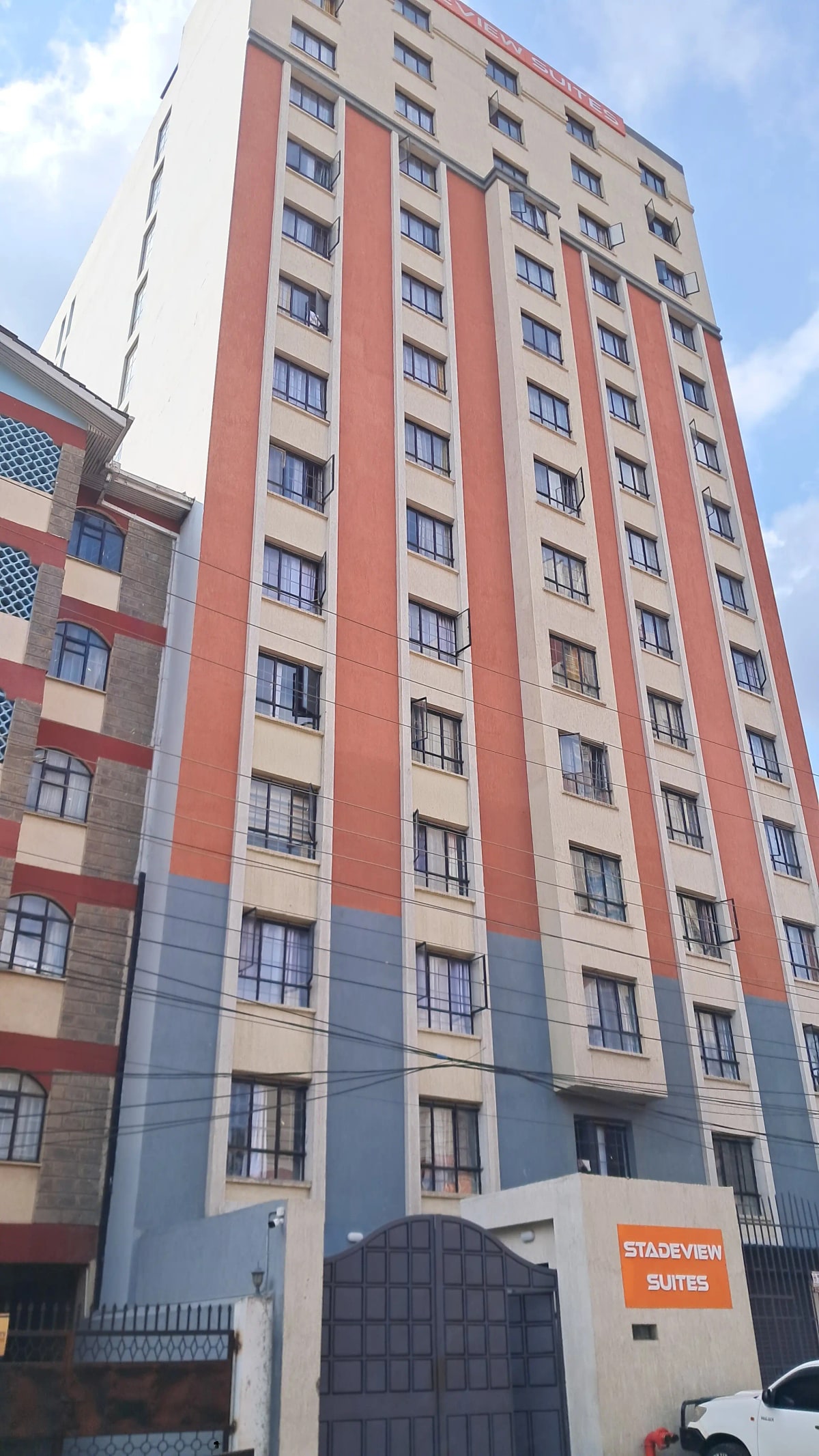 Multi-story residential building with red and cream facade