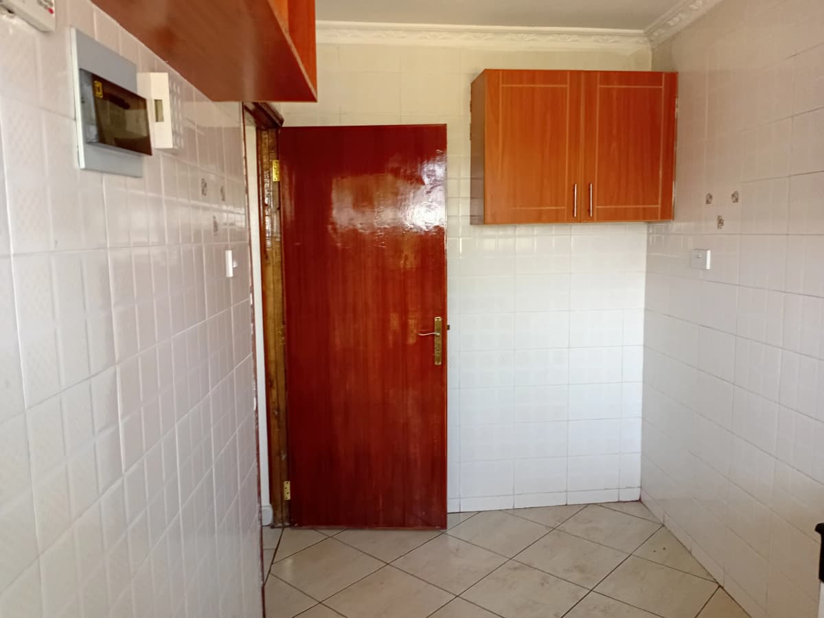Compact kitchen with red door and wooden wall cabinets