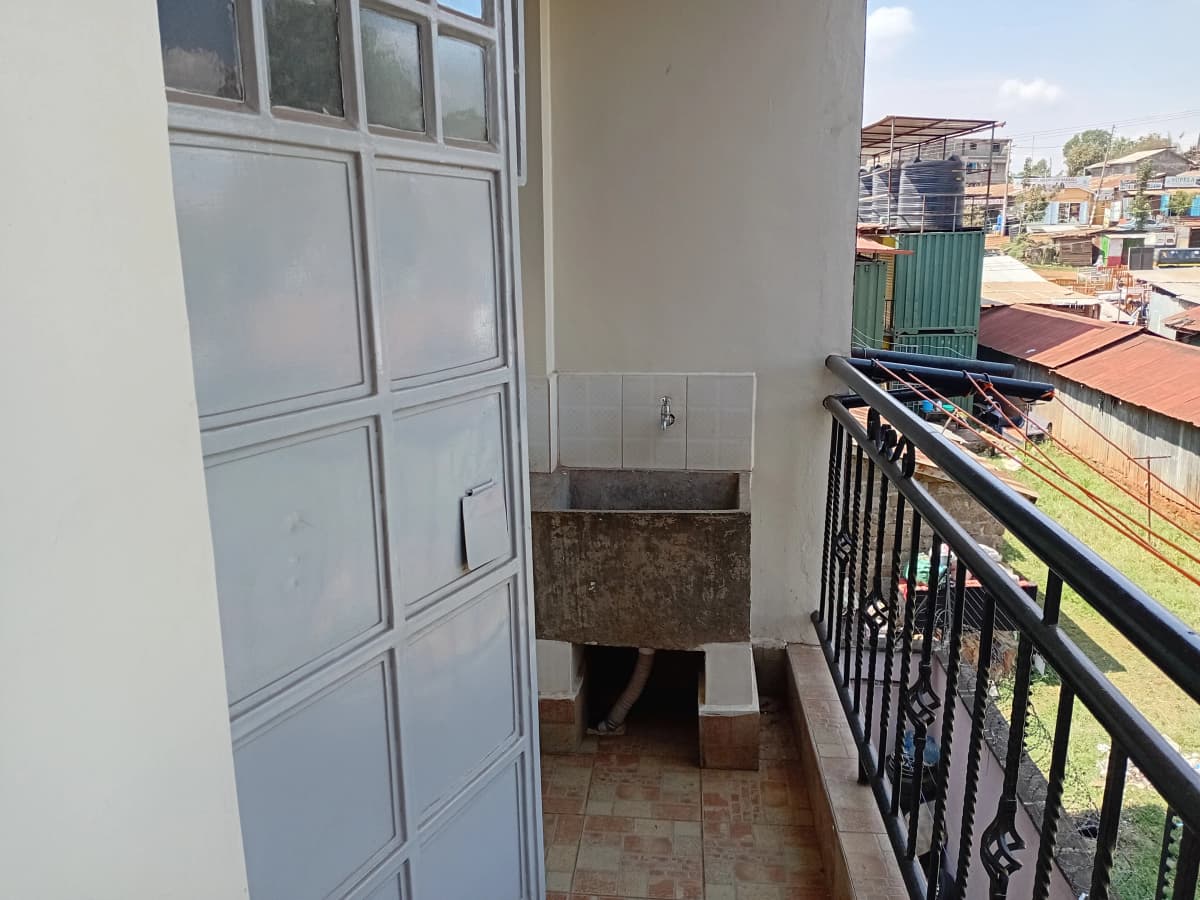 Balcony with metal railing overlooking residential compound