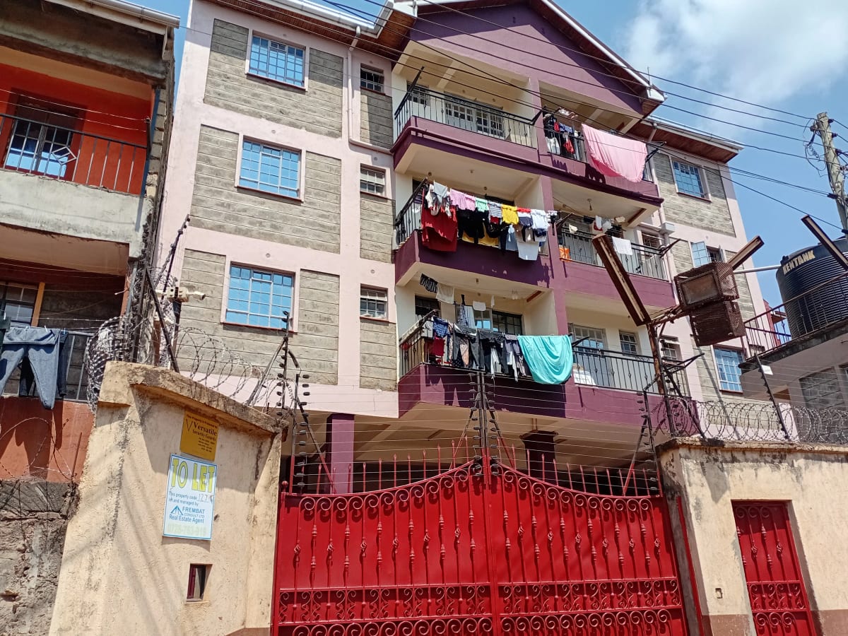 Multi-story residential building with red gates and balconies