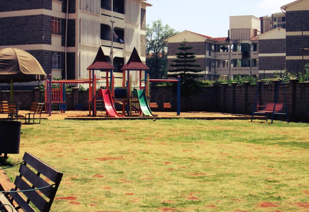 Spacious compound lawn with children's playground and seating