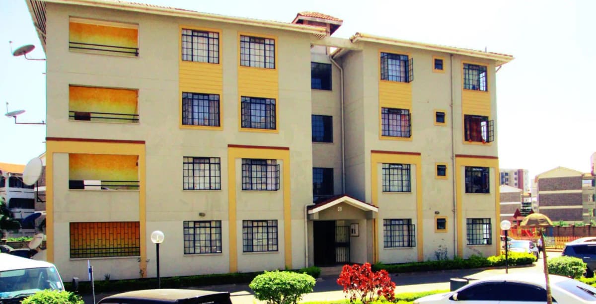 Yellow and cream apartment building facade with manicured grounds