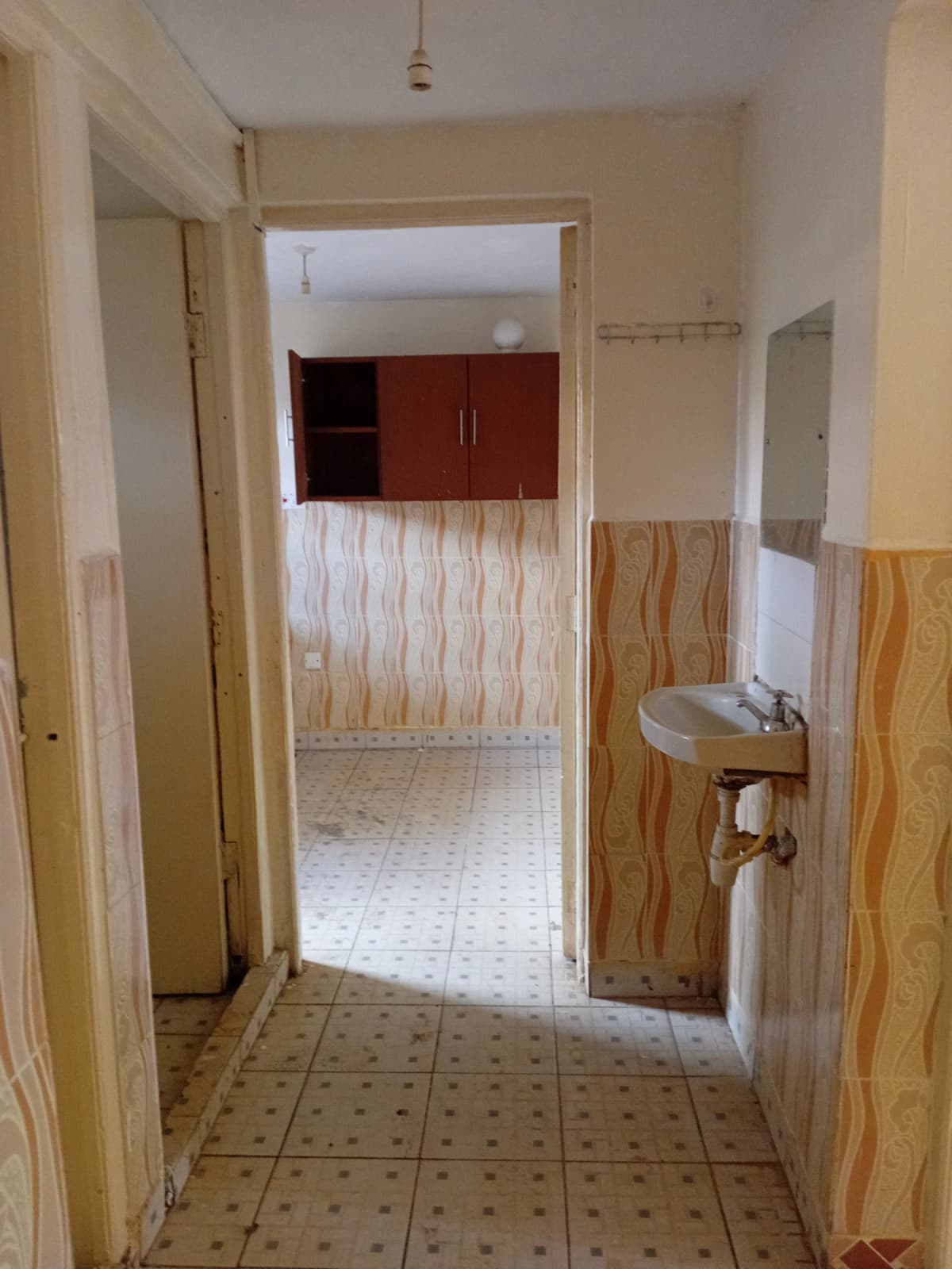 Narrow hallway with tiled floor and basic finishes