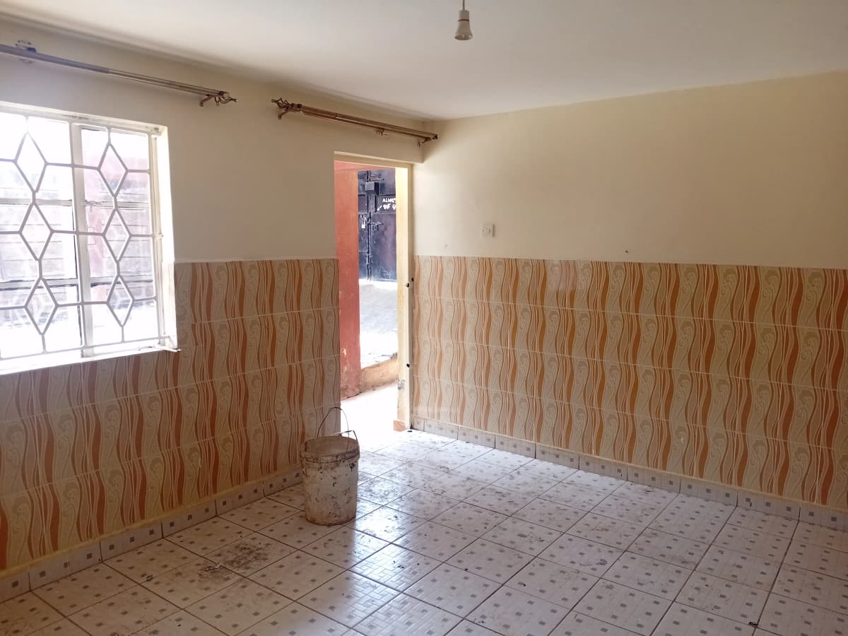 Empty living room with geometric patterned window and wood paneling