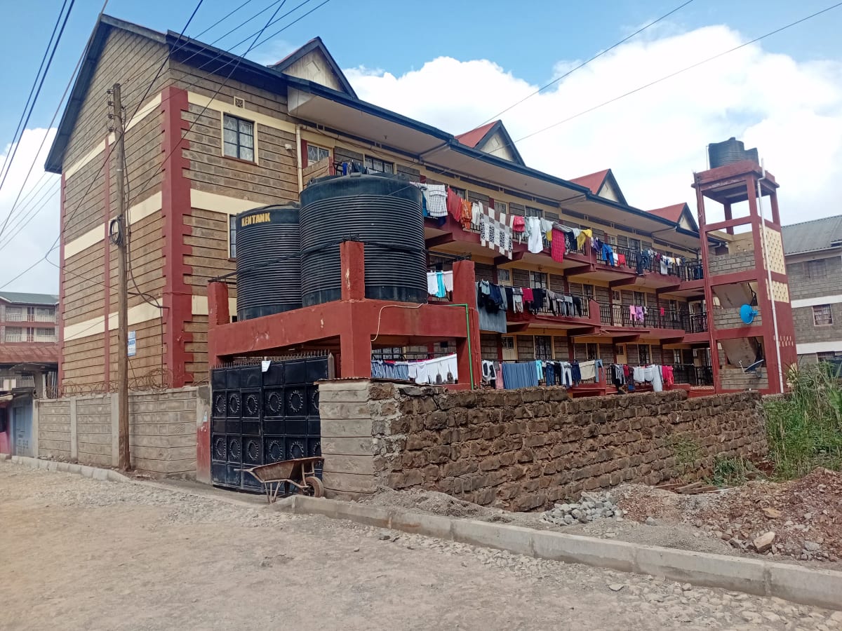 Multi-story residential building with red brick facade and clothesline