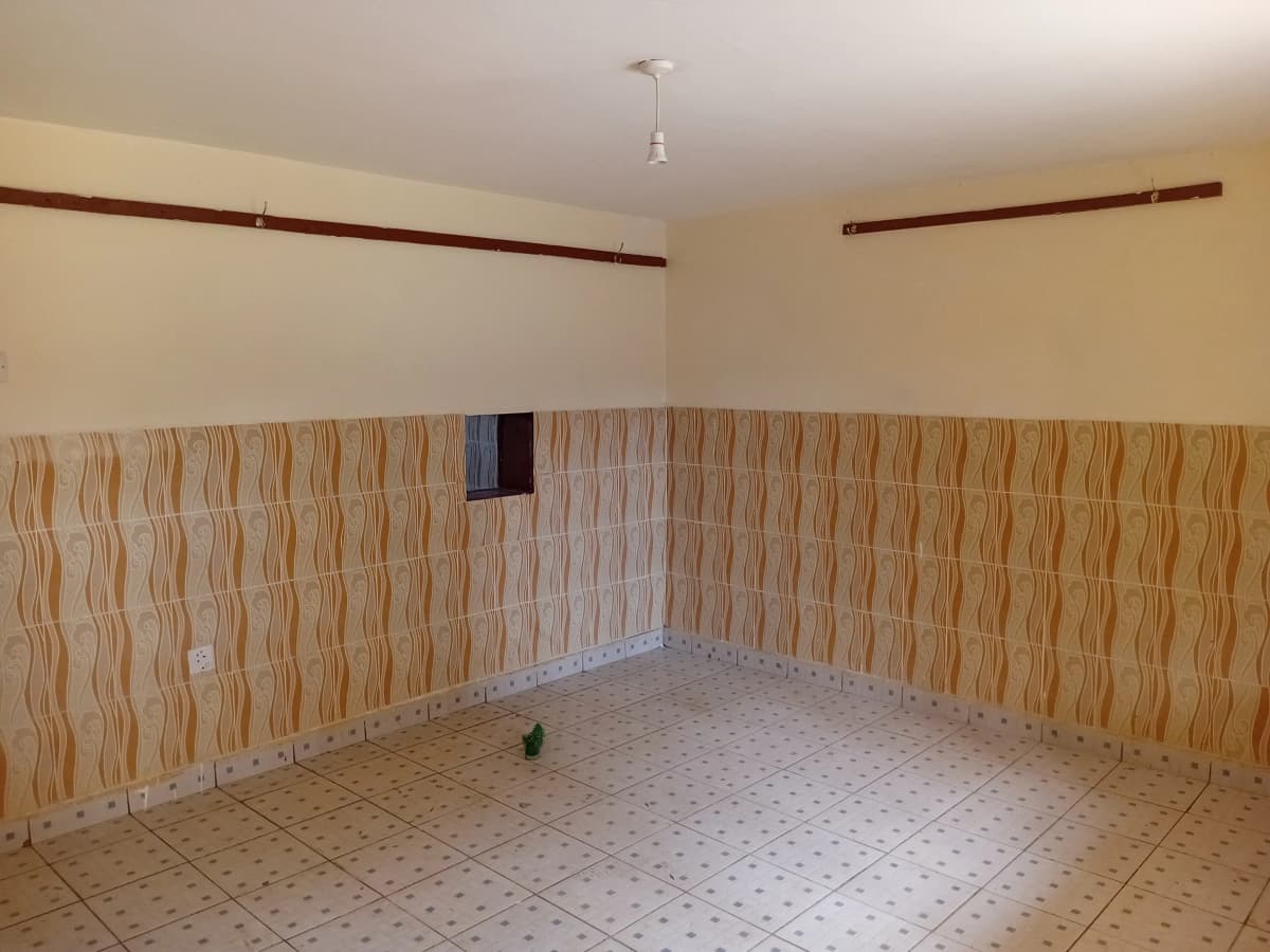 Empty room with brick wall paneling and tiled flooring