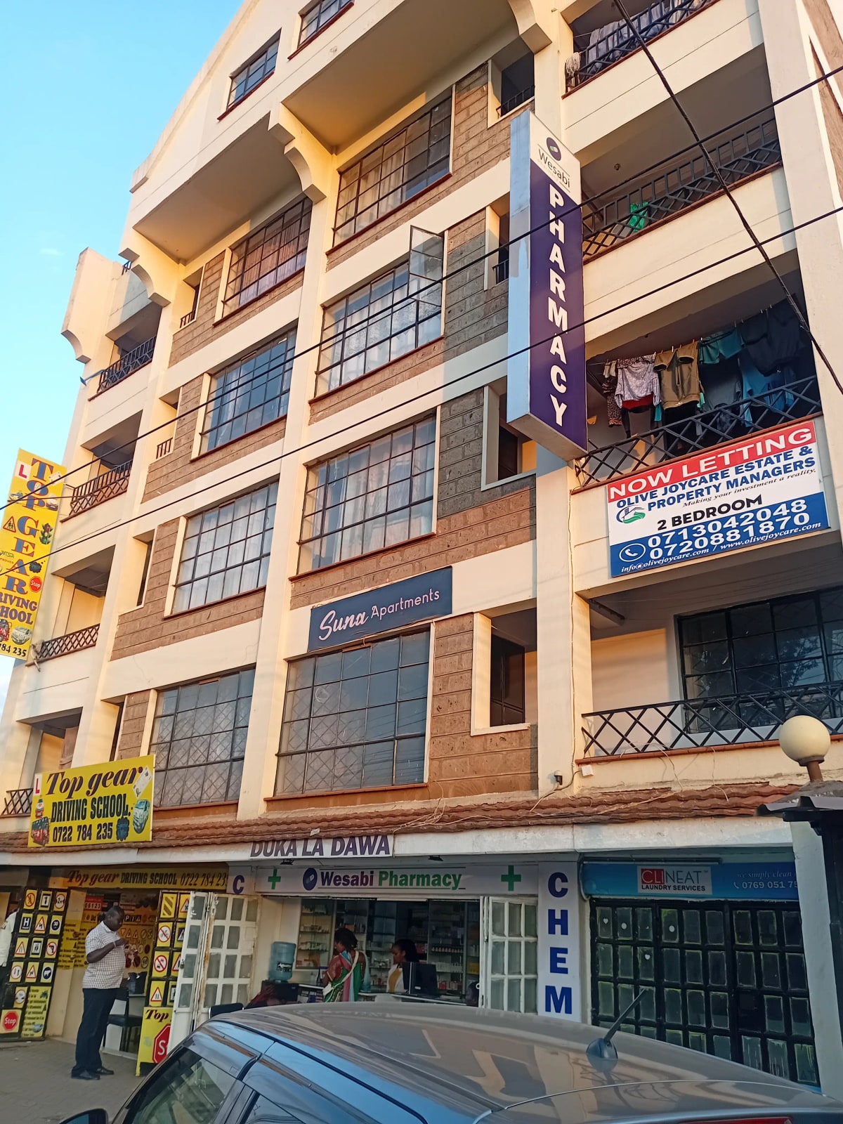 Multi-story residential building facade with street-level commercial shops