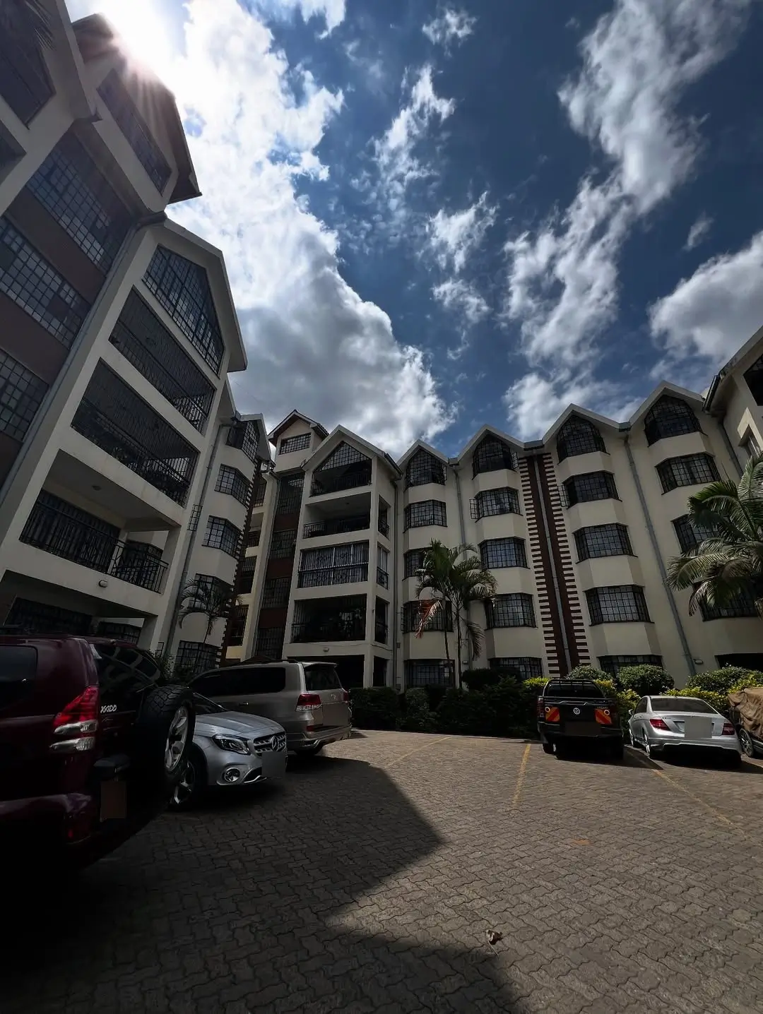 Modern apartment complex with parking courtyard and palm trees