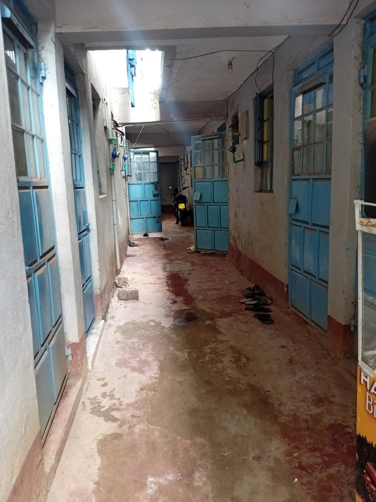 Long corridor with blue doors and wet floor