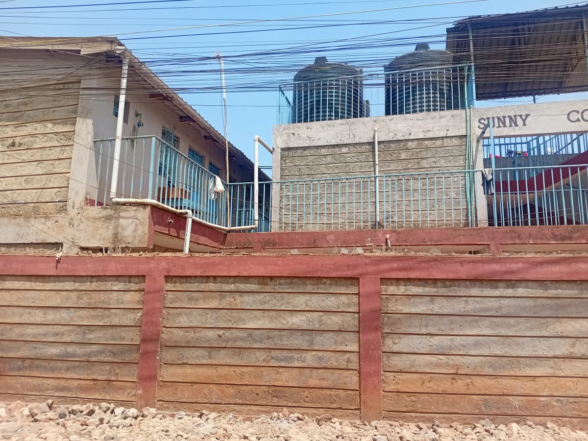 Residential compound with wooden gate and perimeter wall