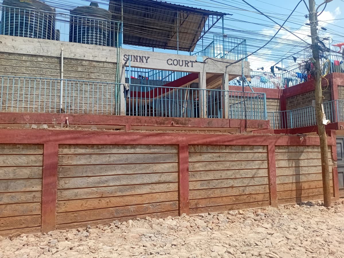 Red wooden gate and compound fence with signage