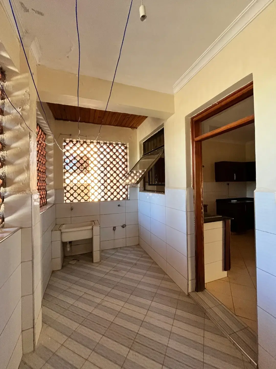 Galley kitchen with tiled flooring and wooden-framed doorway