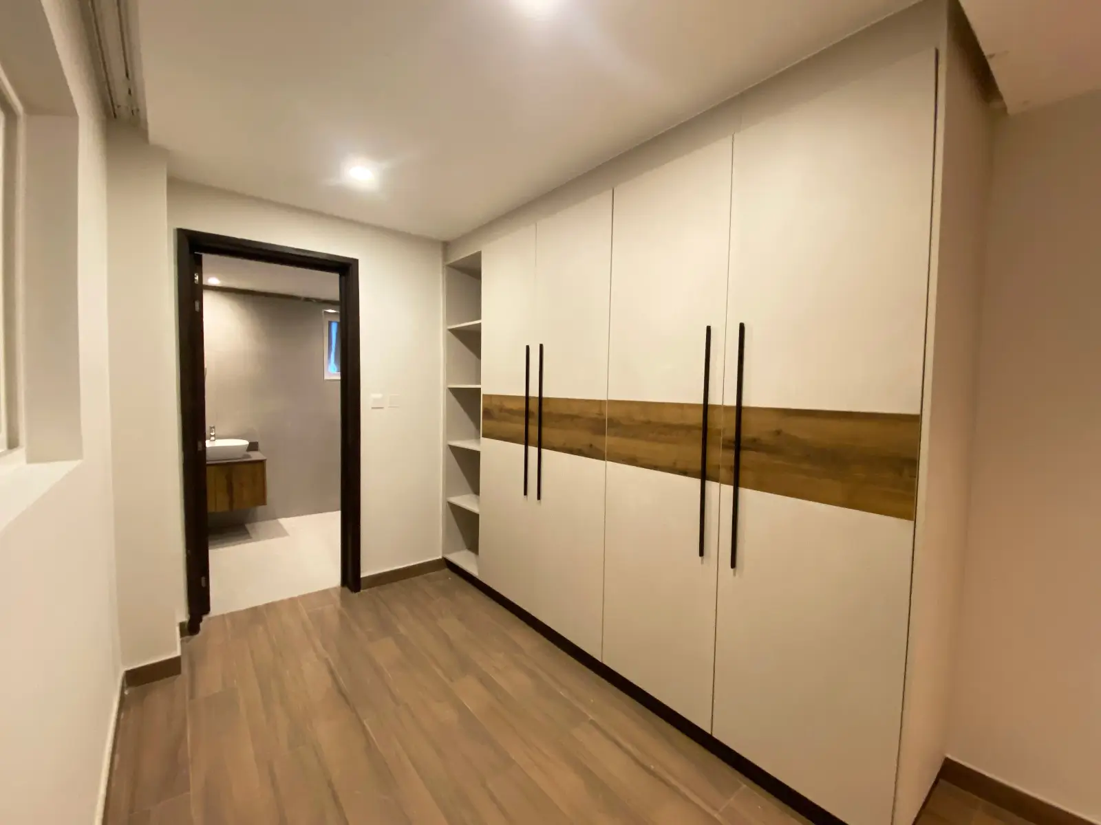 Master bedroom with built-in wardrobes and wooden flooring