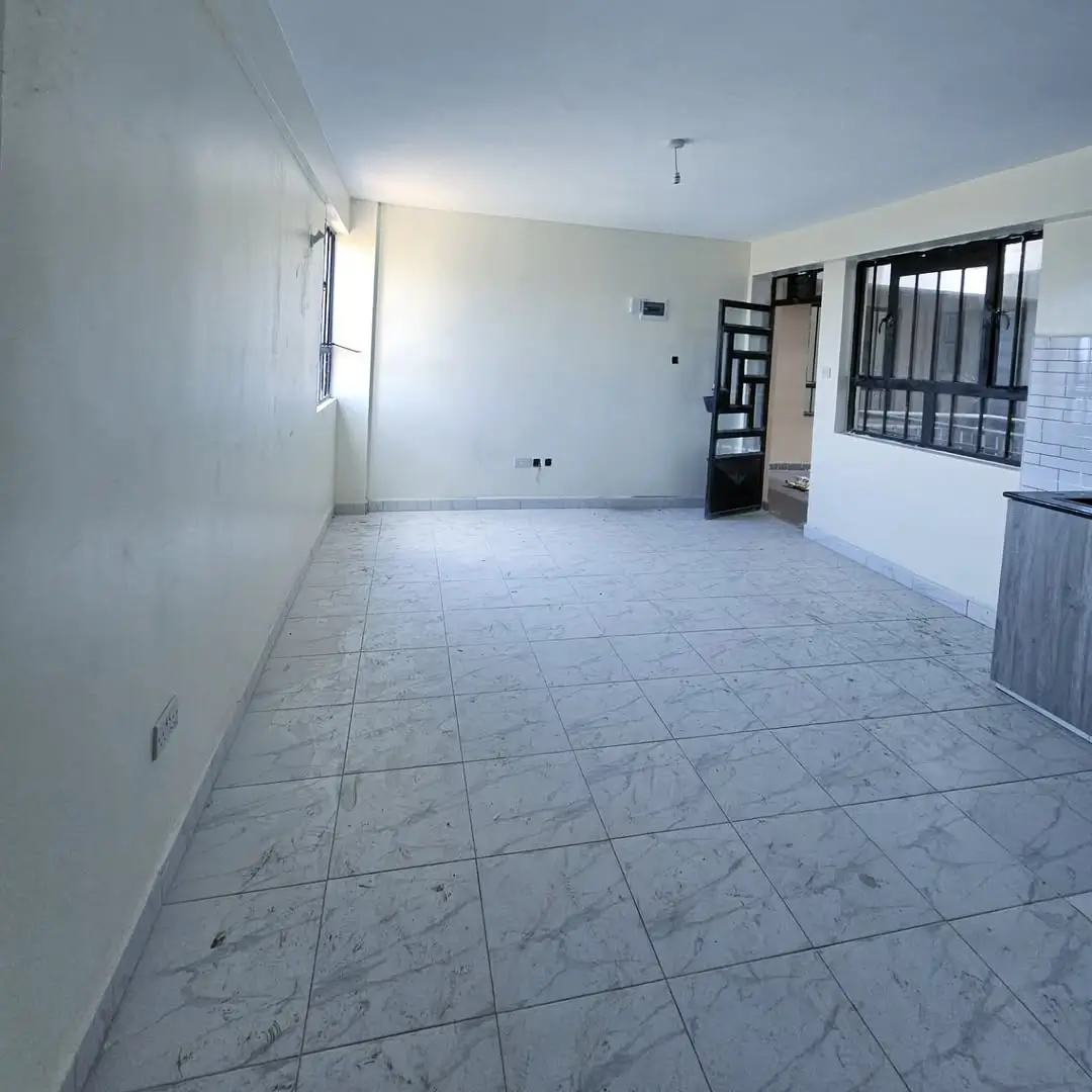Open-plan living area with tiled floors, minimal furnishings