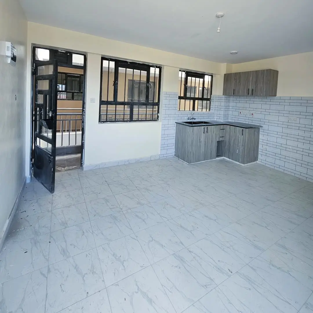 Spacious kitchen with gray cabinetry and white subway tile