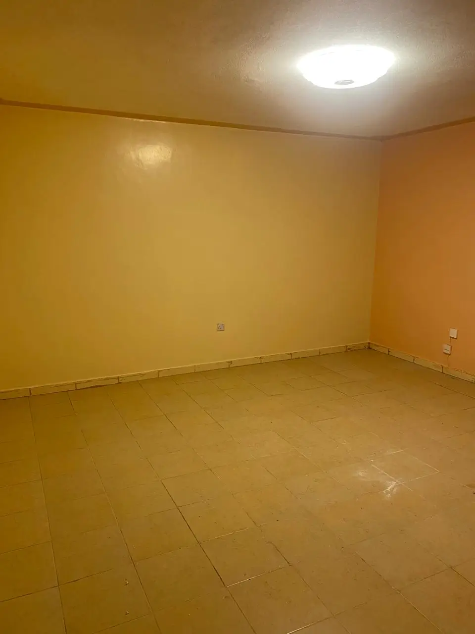 Empty room with yellow walls and tiled flooring