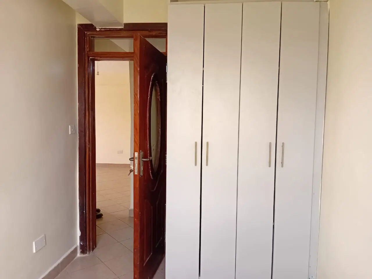 Bedroom with built-in wardrobes and wooden door entry