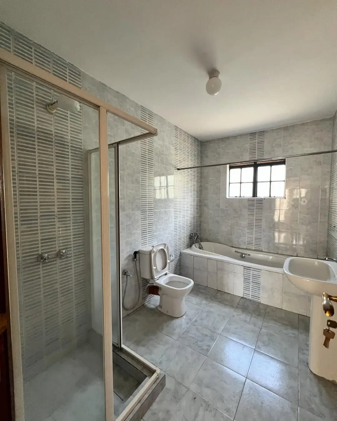 Modern bathroom with walk-in shower, bathtub, and toilet