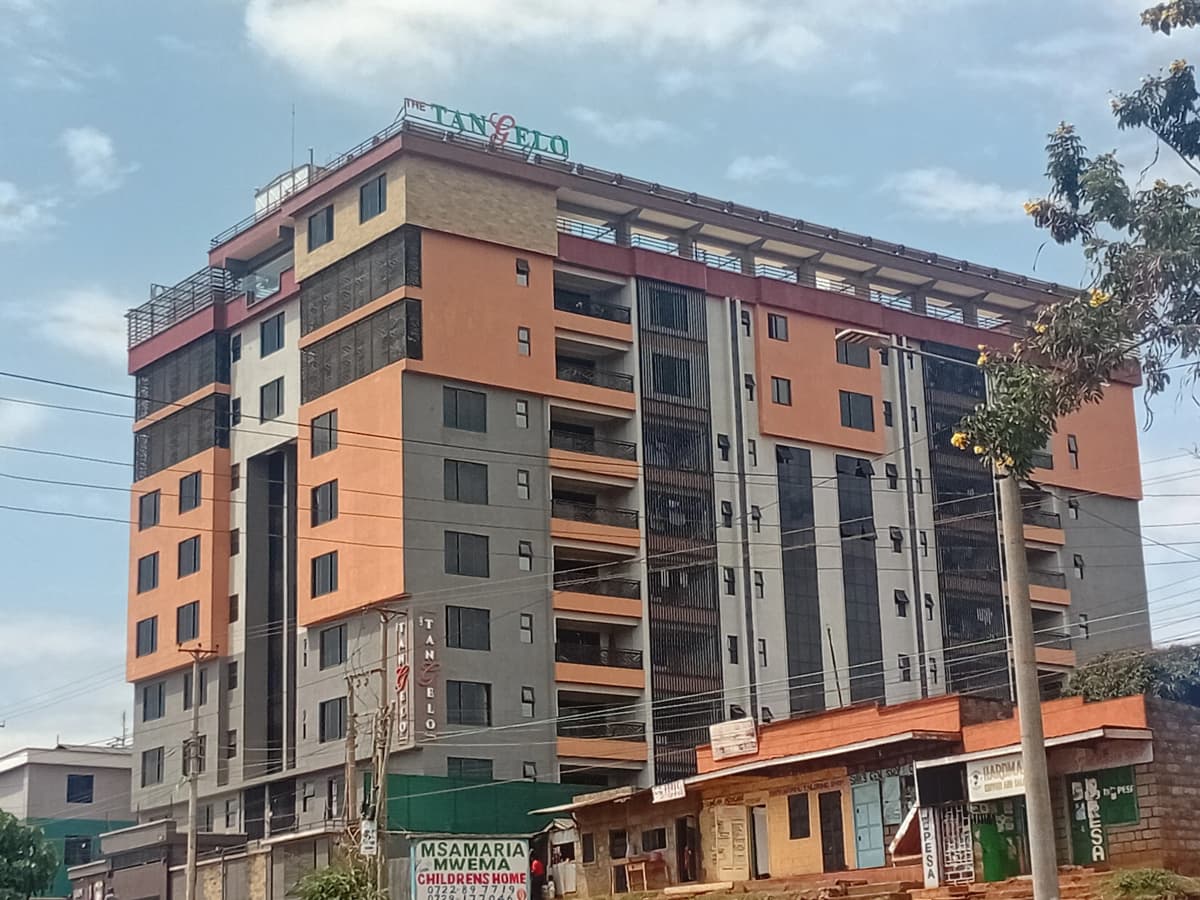 Multi-story residential building facade with orange and gray panels