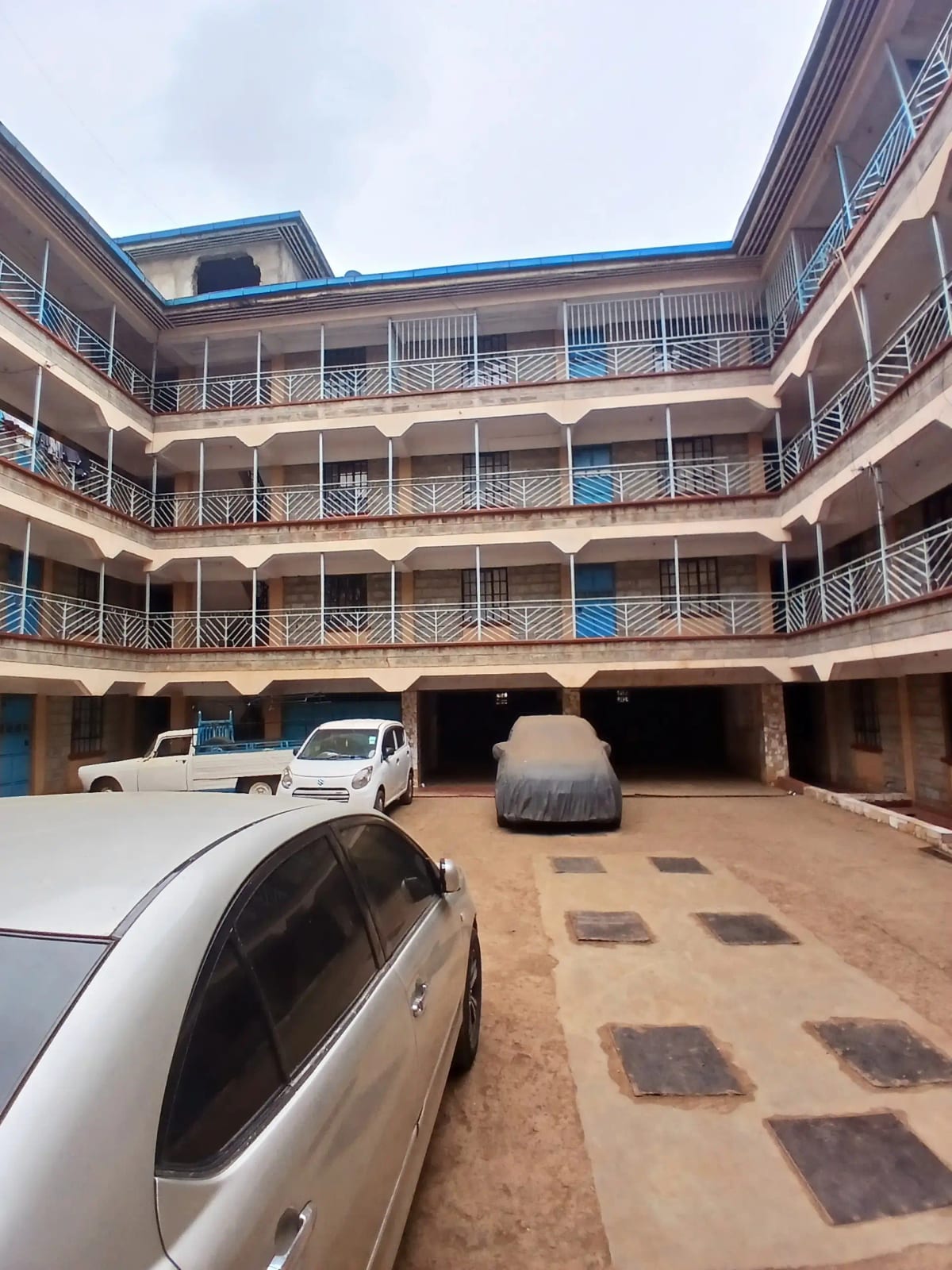 Multi-story apartment complex with ground-level parking bays