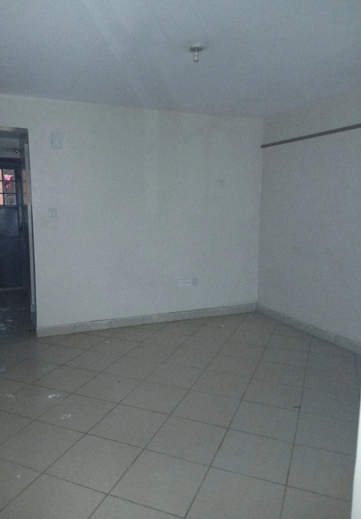 Empty room with tiled floor, minimal furnishings visible