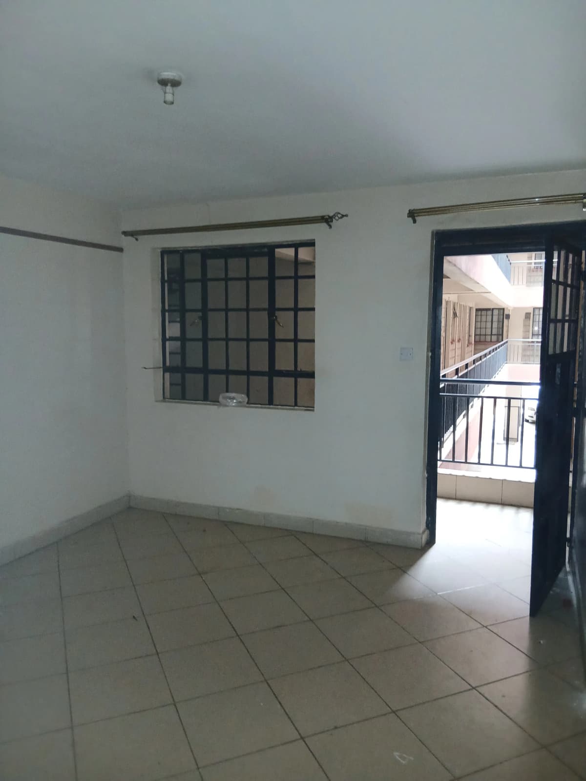 Minimalist living space with tiled floor and balcony access