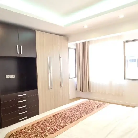 Modern master bedroom with built-in wardrobes and natural light