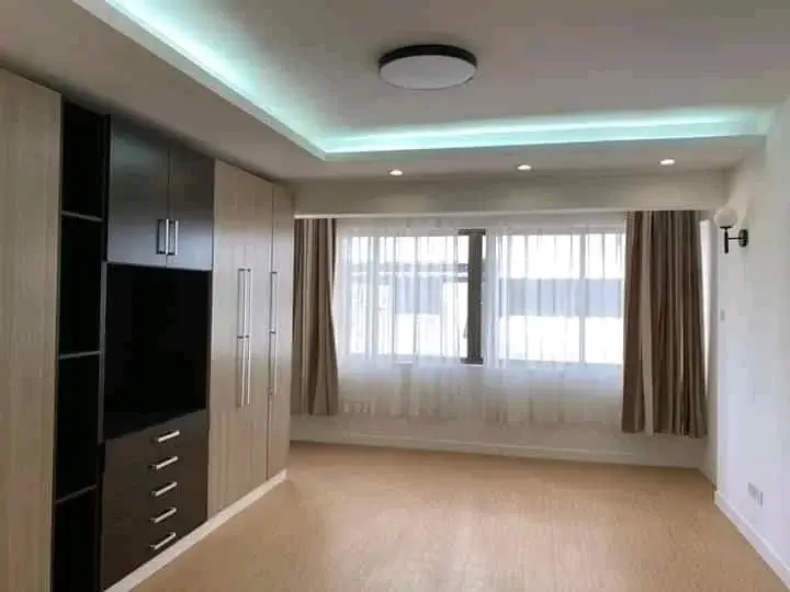 Modern living room with built-in entertainment unit and large windows