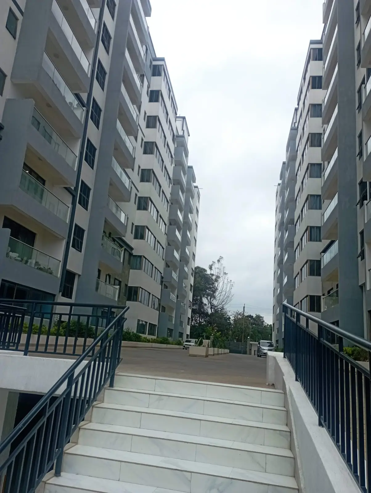 Modern apartment complex with wide pedestrian walkway between buildings