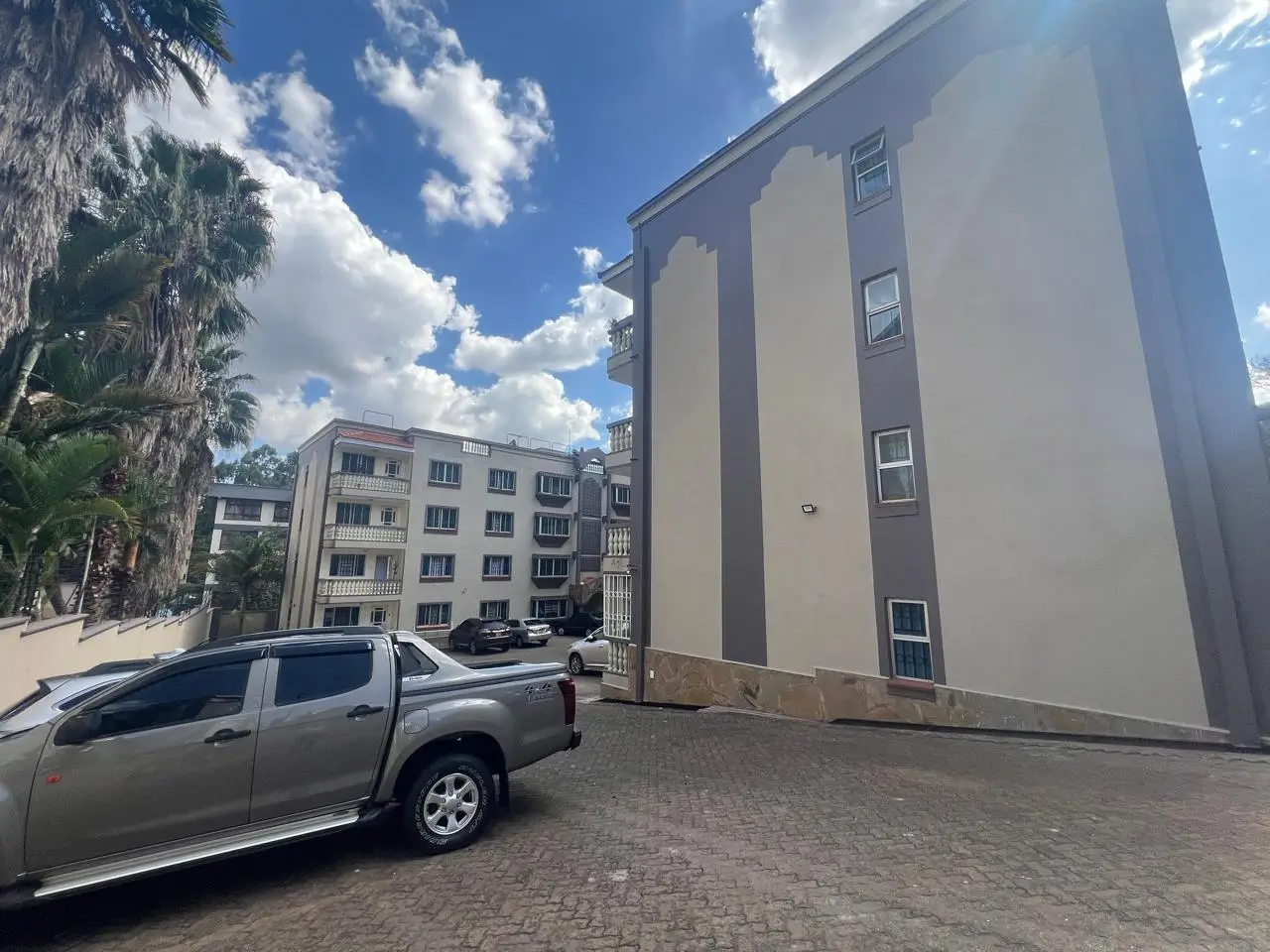 Multi-story residential building facade with parking area
