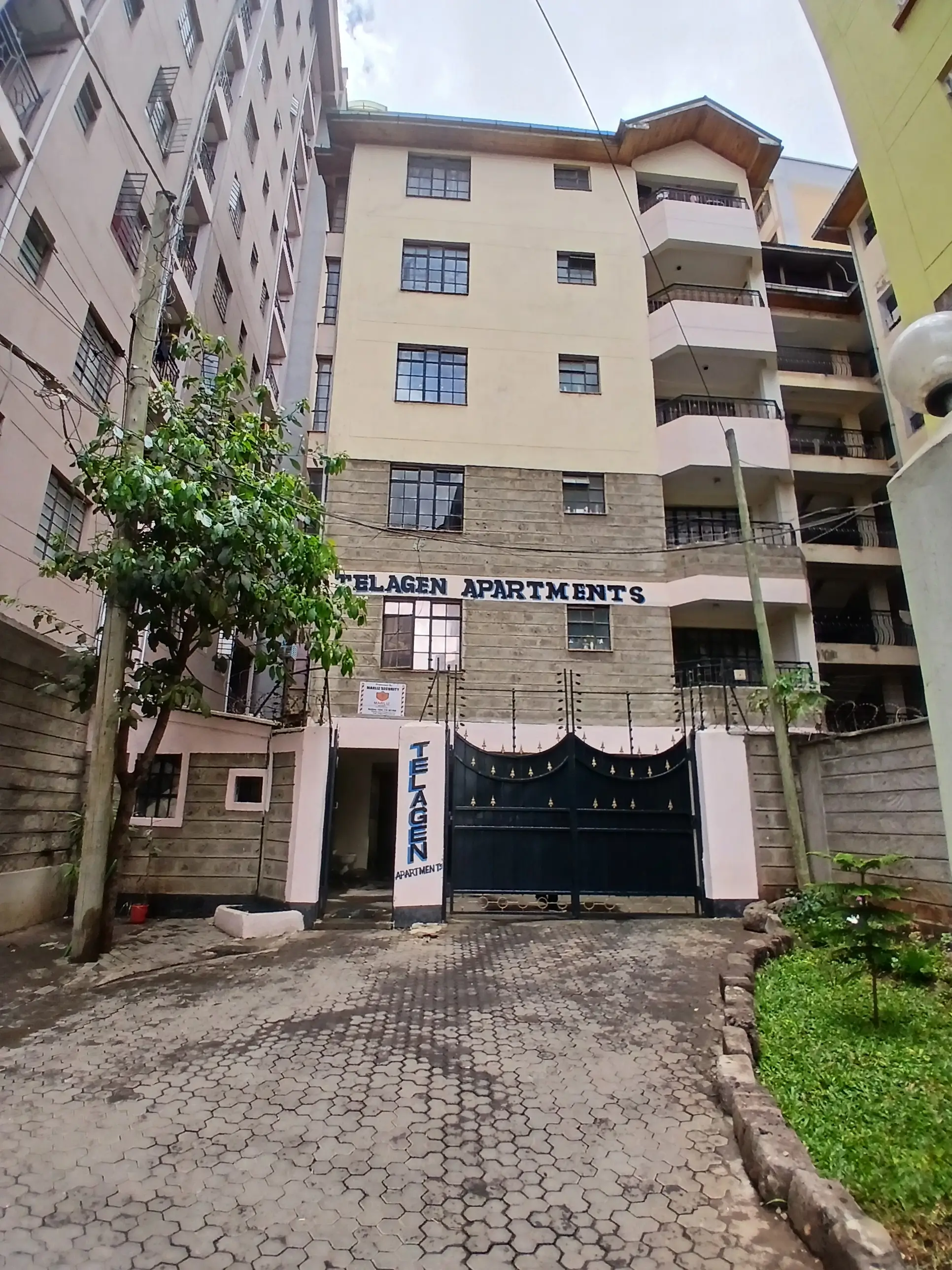 Multi-story apartment building with gated entrance and compound