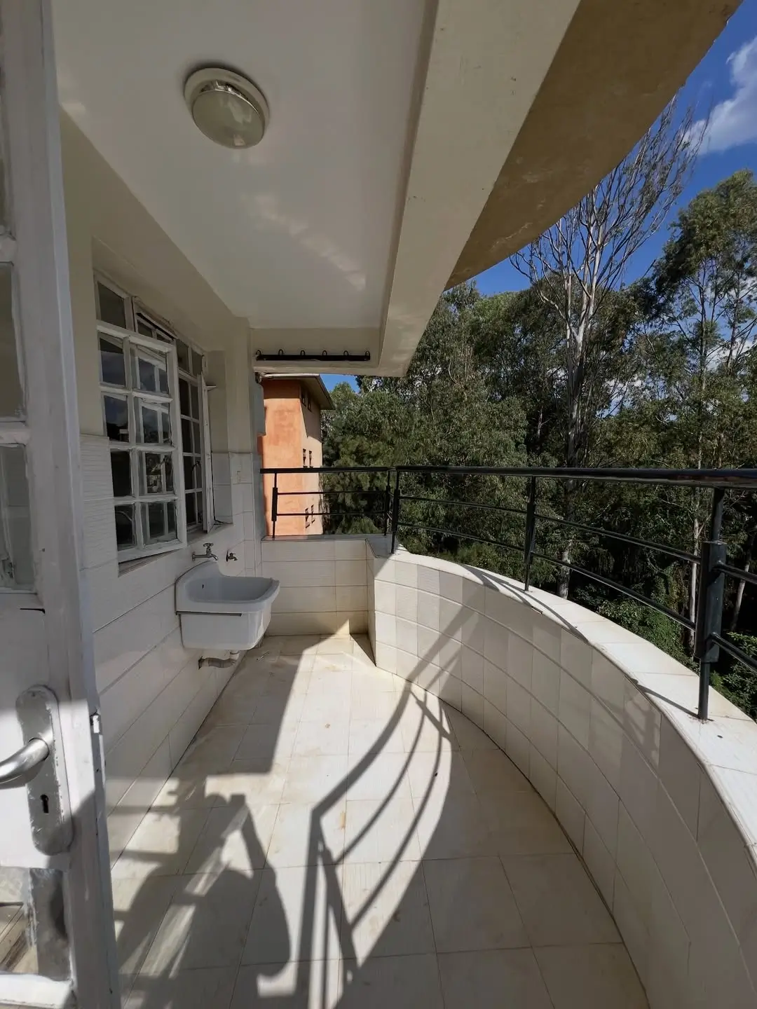 Spacious balcony with railing overlooking green landscape